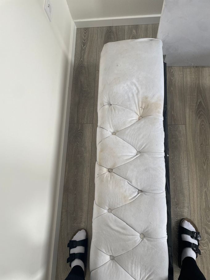 Zašpiněná čalouněná lavice u postele před vyčištěním